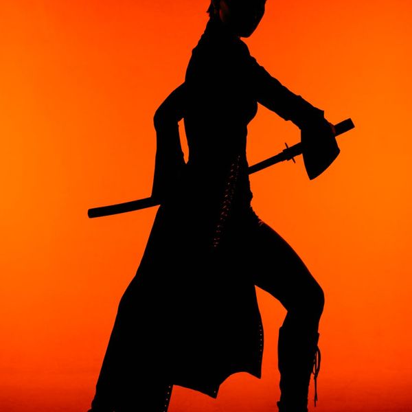 Silhouette of a man in a focused, powerful stance against a vibrant background.